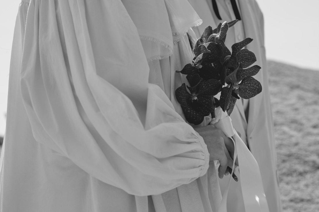 白い衣装と黒い花のモノクロ写真